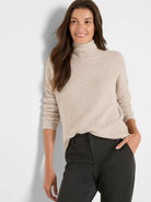 Beige waffle knit sweater with a high neck and relaxed fit.