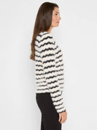 Fuzzy off-white sweater with black horizontal wavy stripes.
