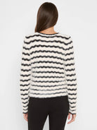 Off-white and black fuzzy sweater with wavy horizontal stripes.