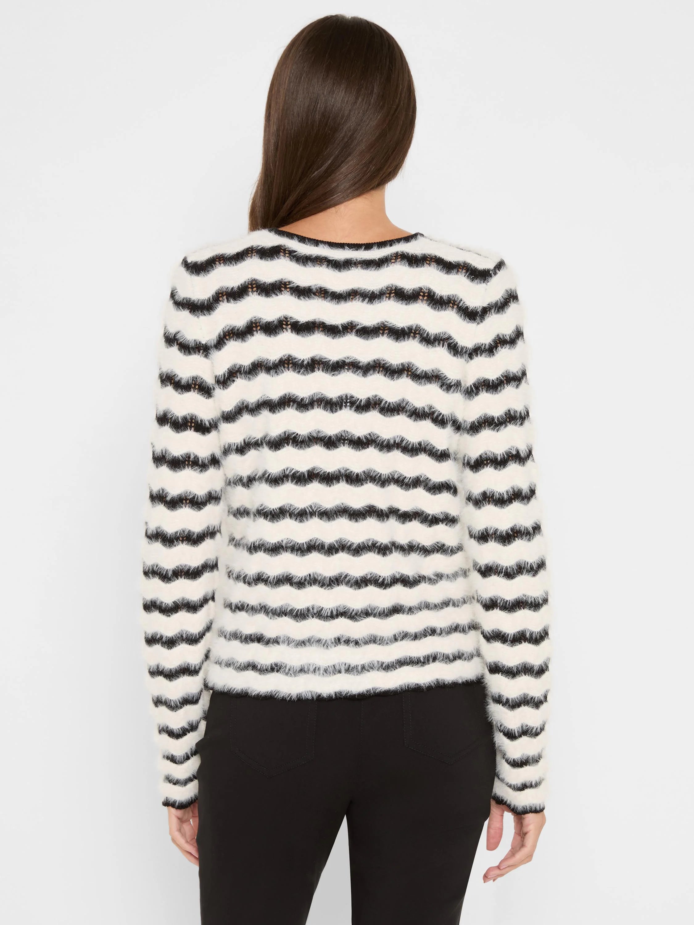 Off-white and black fuzzy sweater with wavy horizontal stripes.