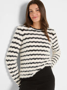 Cream and black fuzzy sweater with horizontal wavy stripes and a crew neck, worn by a model.
