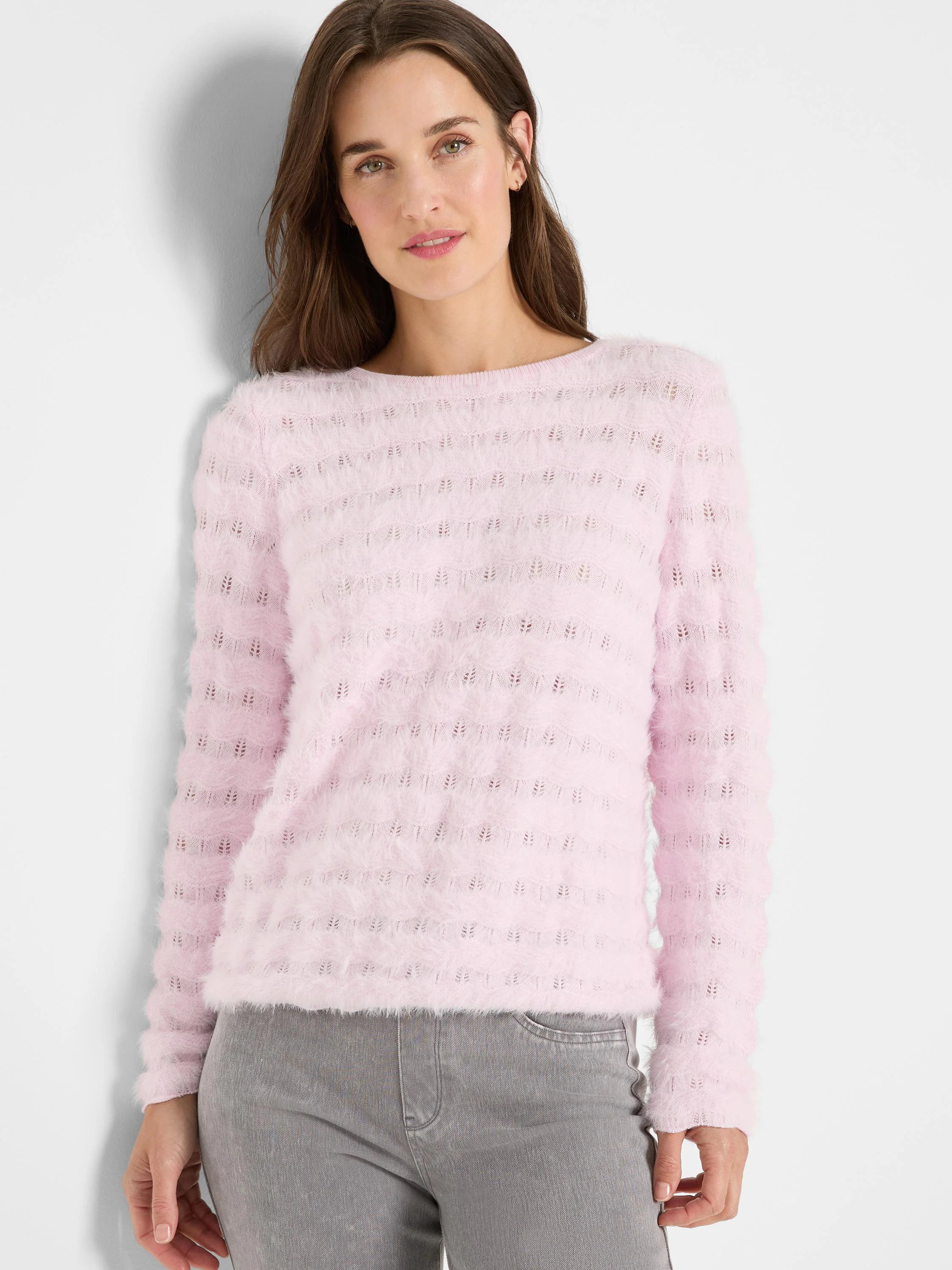 Pale pink fluffy sweater with horizontal bands of textured knit, creating a subtle wavy pattern.