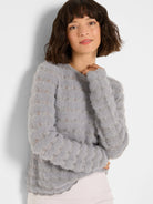 Light grey fuzzy sweater with a wavy open-knit pattern in vertical rows.