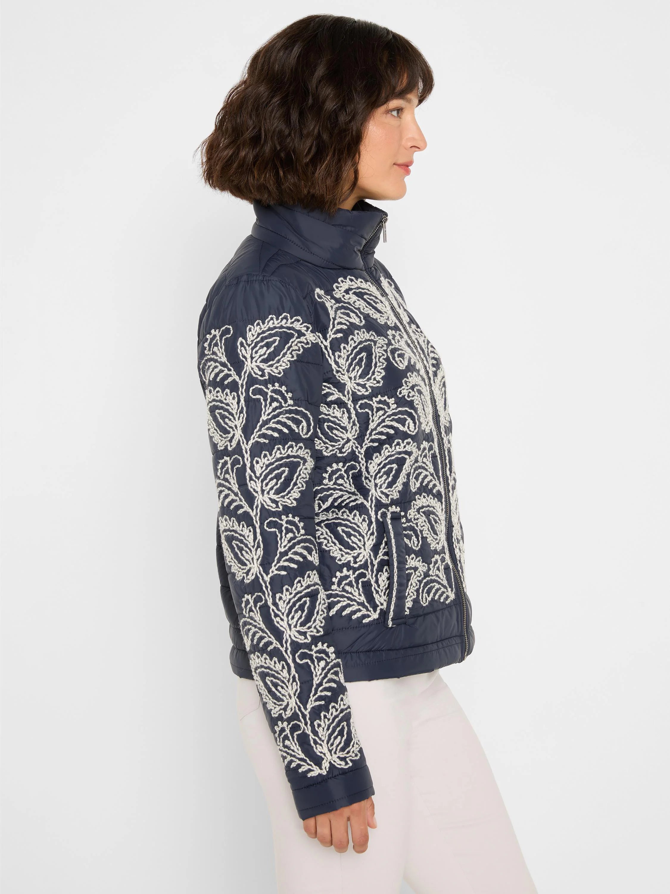 Navy puffer bomber jacket with white botanical embroidery on front and sleeves.