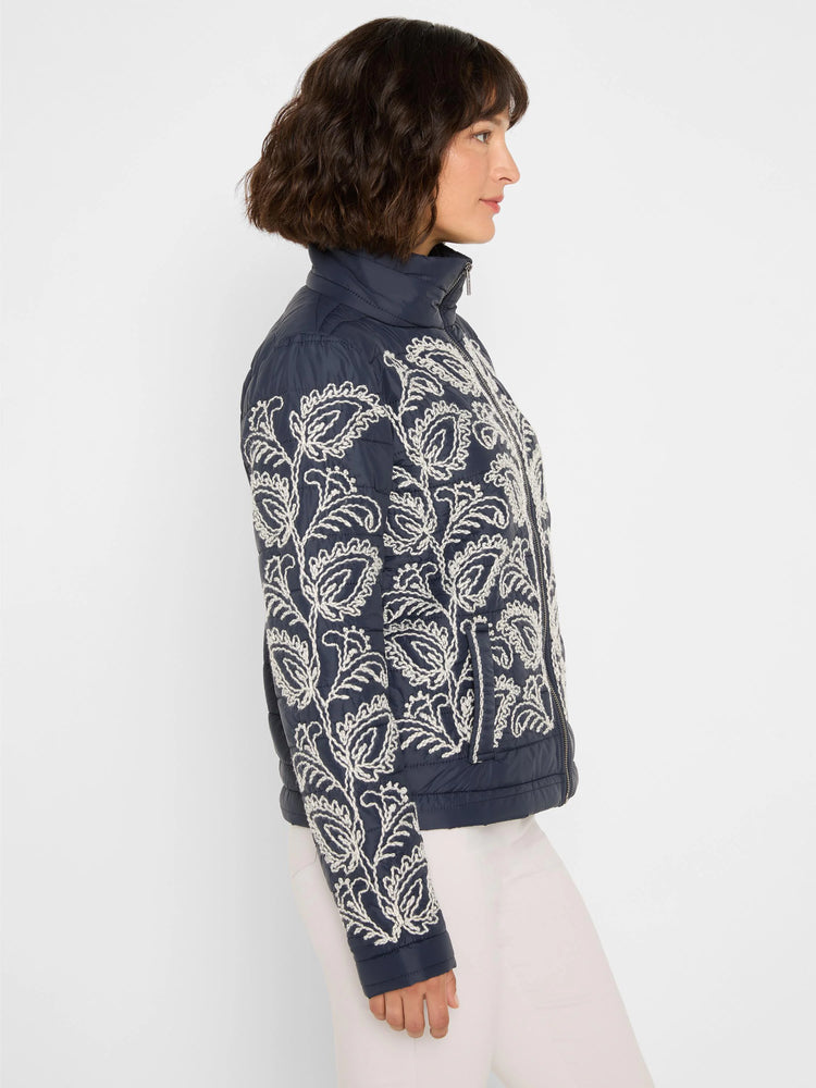 Navy puffer bomber jacket with white botanical embroidery on front and sleeves.