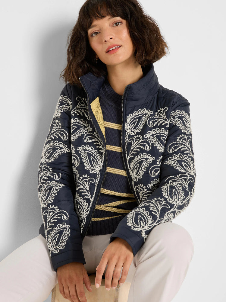Navy puffer bomber jacket with prominent cream floral embroidery throughout, high collar, and zip front.