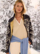 Dark blue puffer bomber with cream intricate embroidery on sleeves & body. Mustard yellow lining visible.