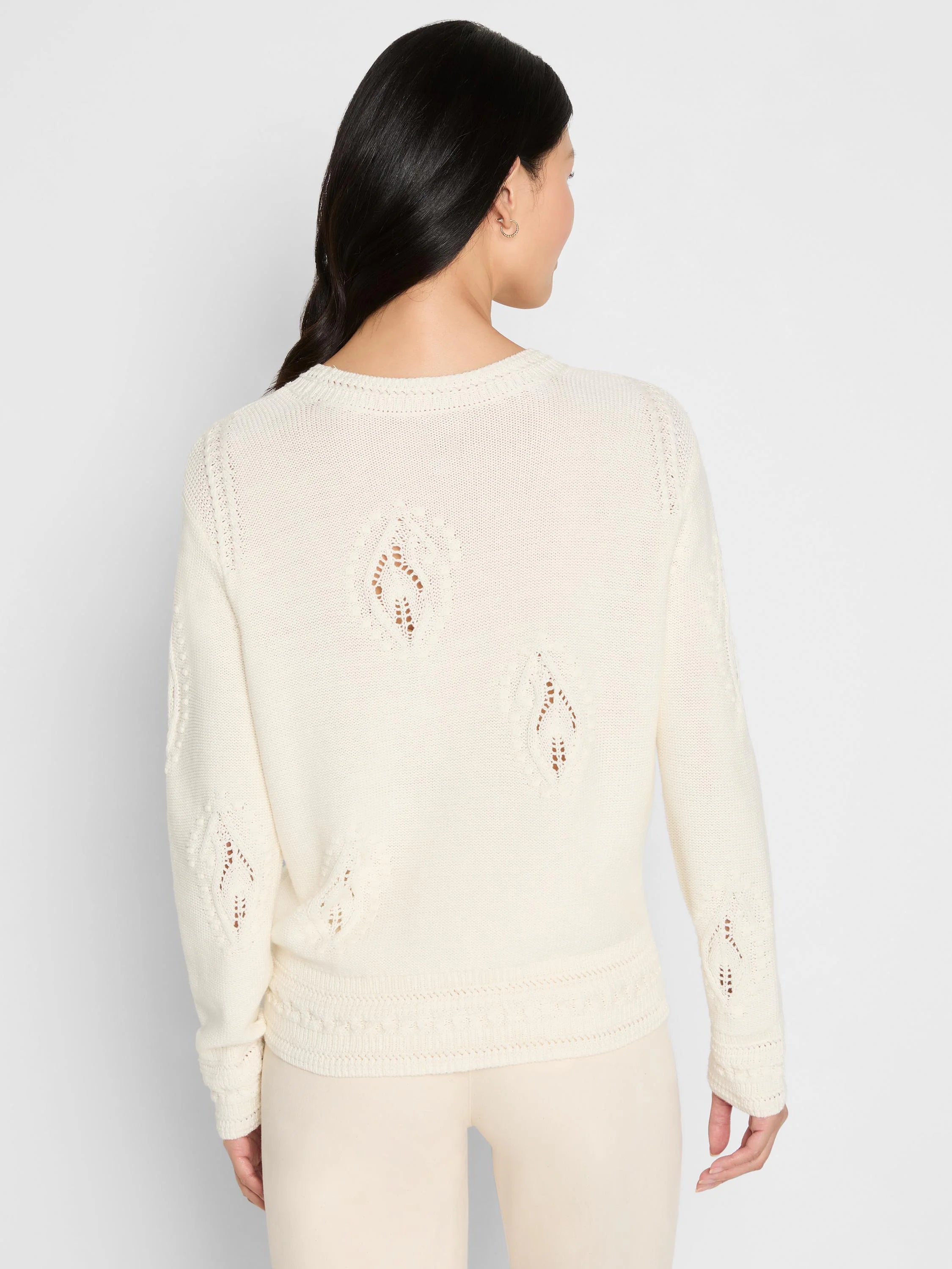 Off-white sweater with open-knit paisley patterns and raised dot textures on the back, sleeves, and front hem.