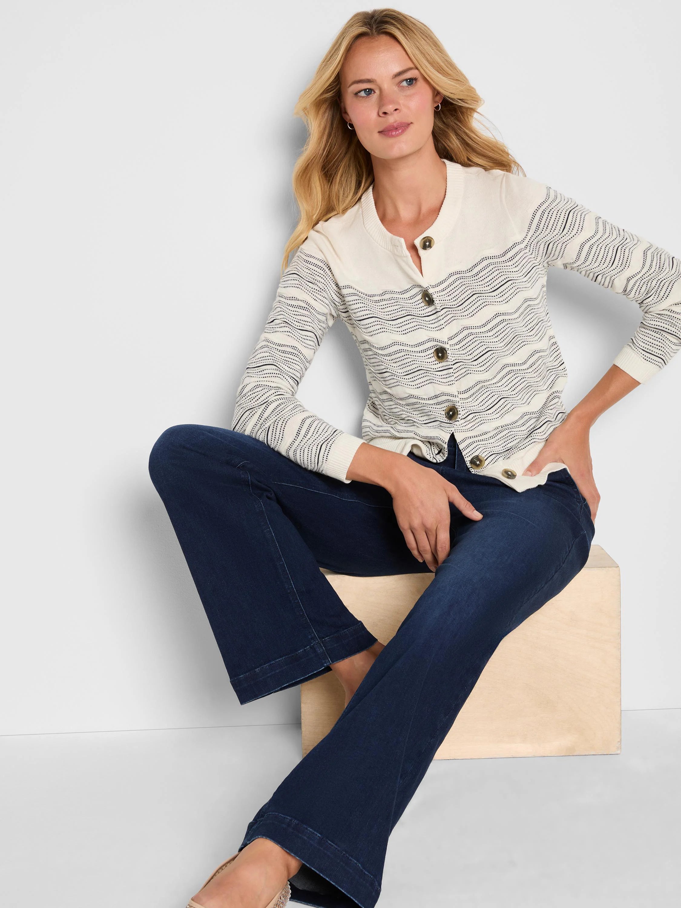 Cream cardigan with dark grey dotted zig-zag patterns and matching front buttons.