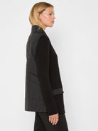Black blazer with knitted front and sleeves, featuring a puffed, quilted back panel.