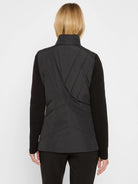 Black blazer, back view: high collar, padded back with geometric stitching, ribbed knit sleeves.