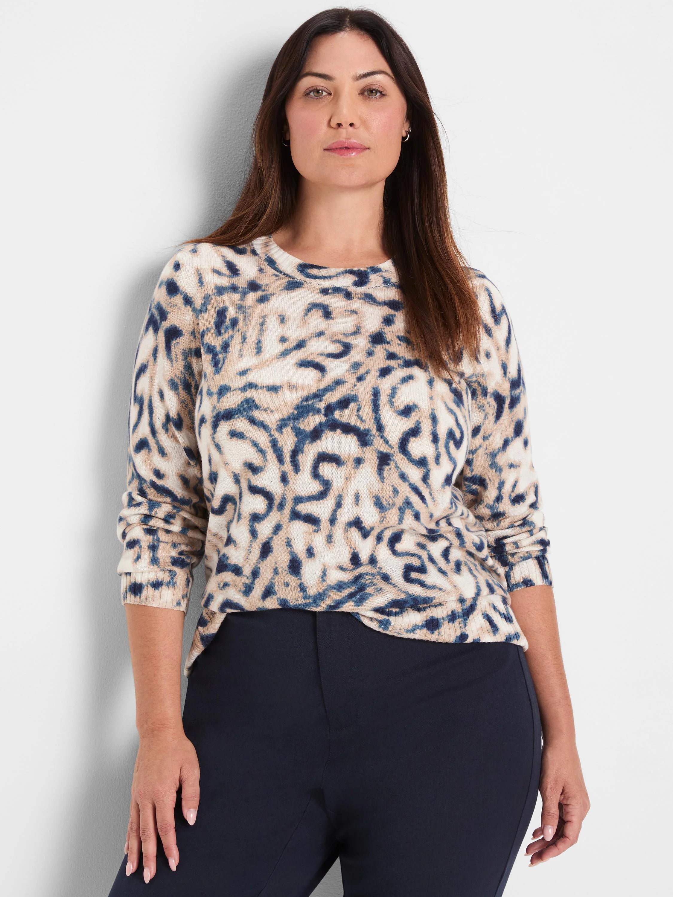 Cream sweater with blue and tan blurry leaf pattern, crew neck, long sleeves.