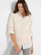 Cream V-neck shaker stitch sweater.