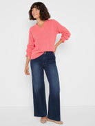 Coral pink V-neck sweater with ribbed texture and cuffed long sleeves.