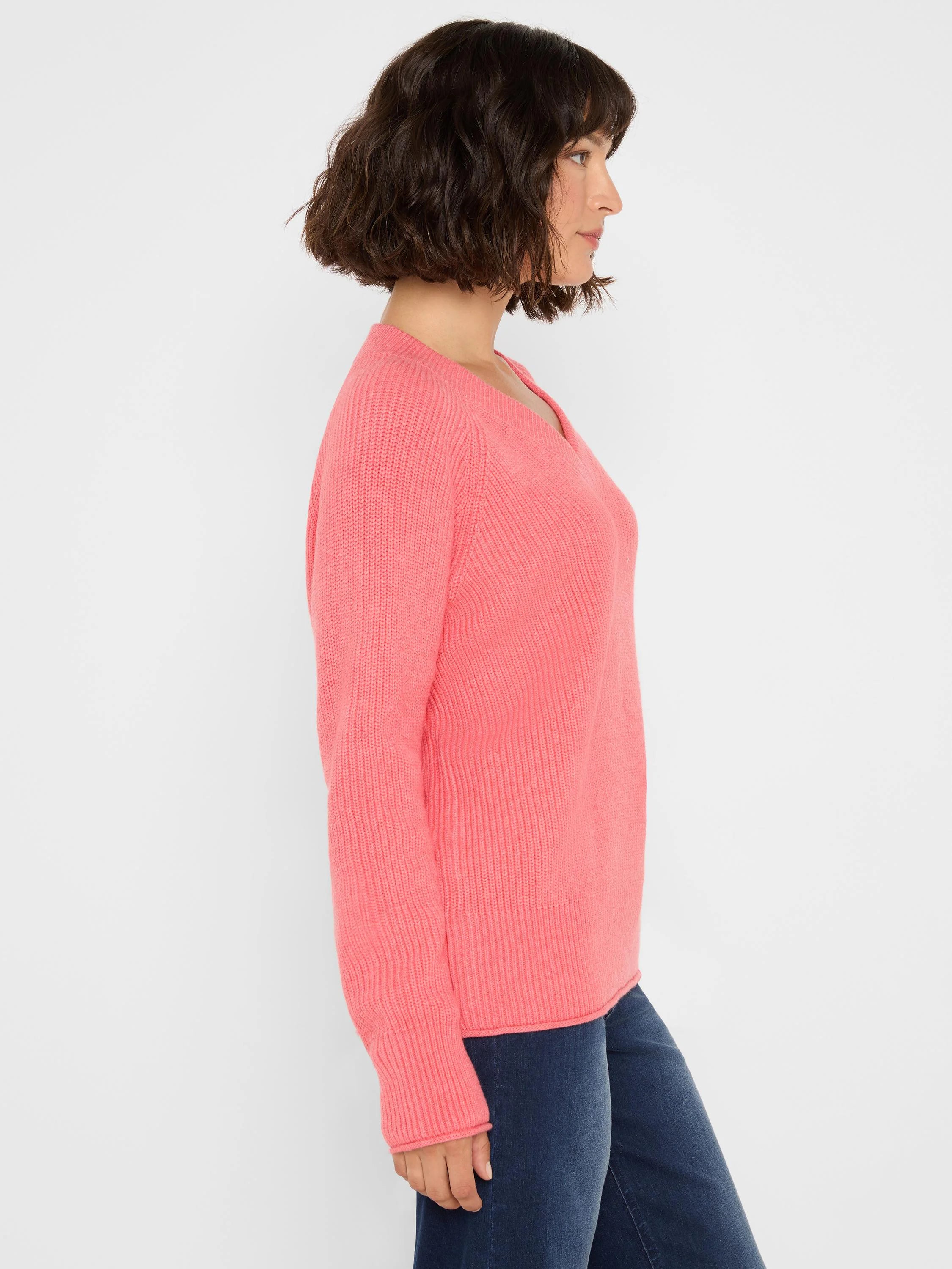 Coral pink V-neck sweater with prominent shaker stitch ribs.