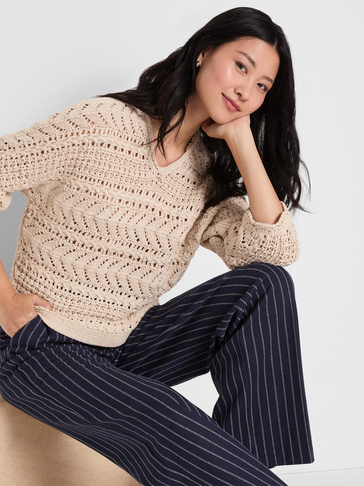 Oatmeal V-neck sweater with an open-knit chevron pattern from tape yarn stitches.