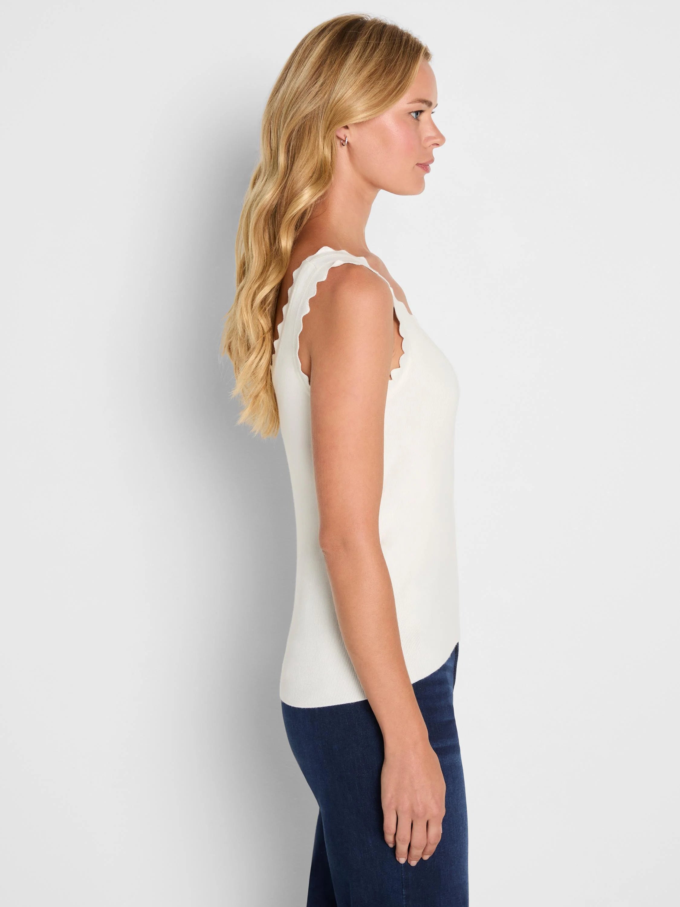 Cream ribbed sweater tank with scalloped armholes and neckline.