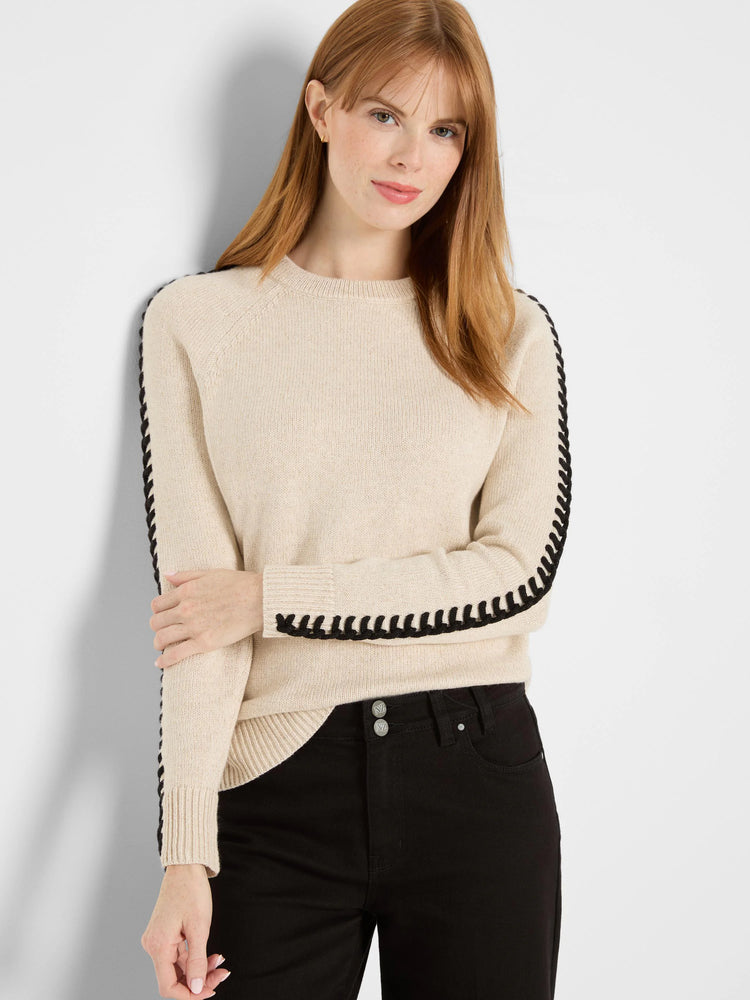 Cream metallic sweater with black braided trim on raglan sleeves and cuffs.