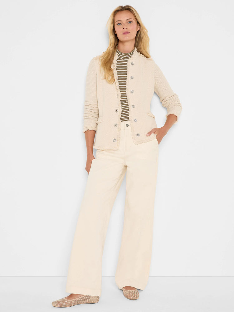Cream knit jacket with silver buttons, frayed fringe trim along edges, standing collar, and four front pockets.