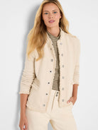 Cream textured knit jacket with fringe edges, silver snap buttons, and a collarless neckline.