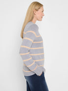 Light grey sweater with horizontal pale peach stripes.
