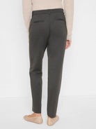Dark grey trousers, back view. Features two back welt pockets, belt loops. Worn full length.