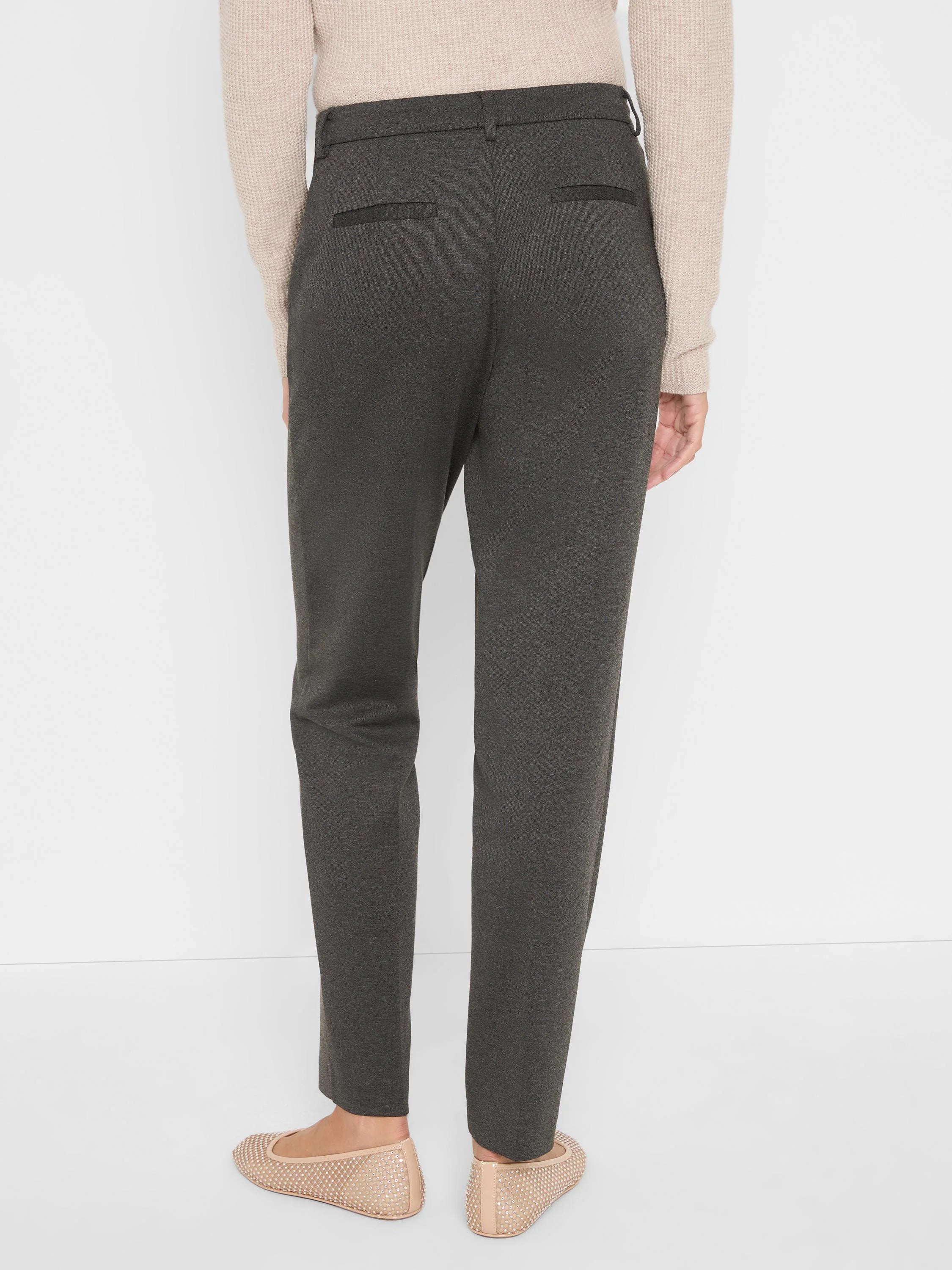 Dark gray ponte knit trousers on a model, seen from behind. Features two back welt pockets and a straight, ankle-length fit.