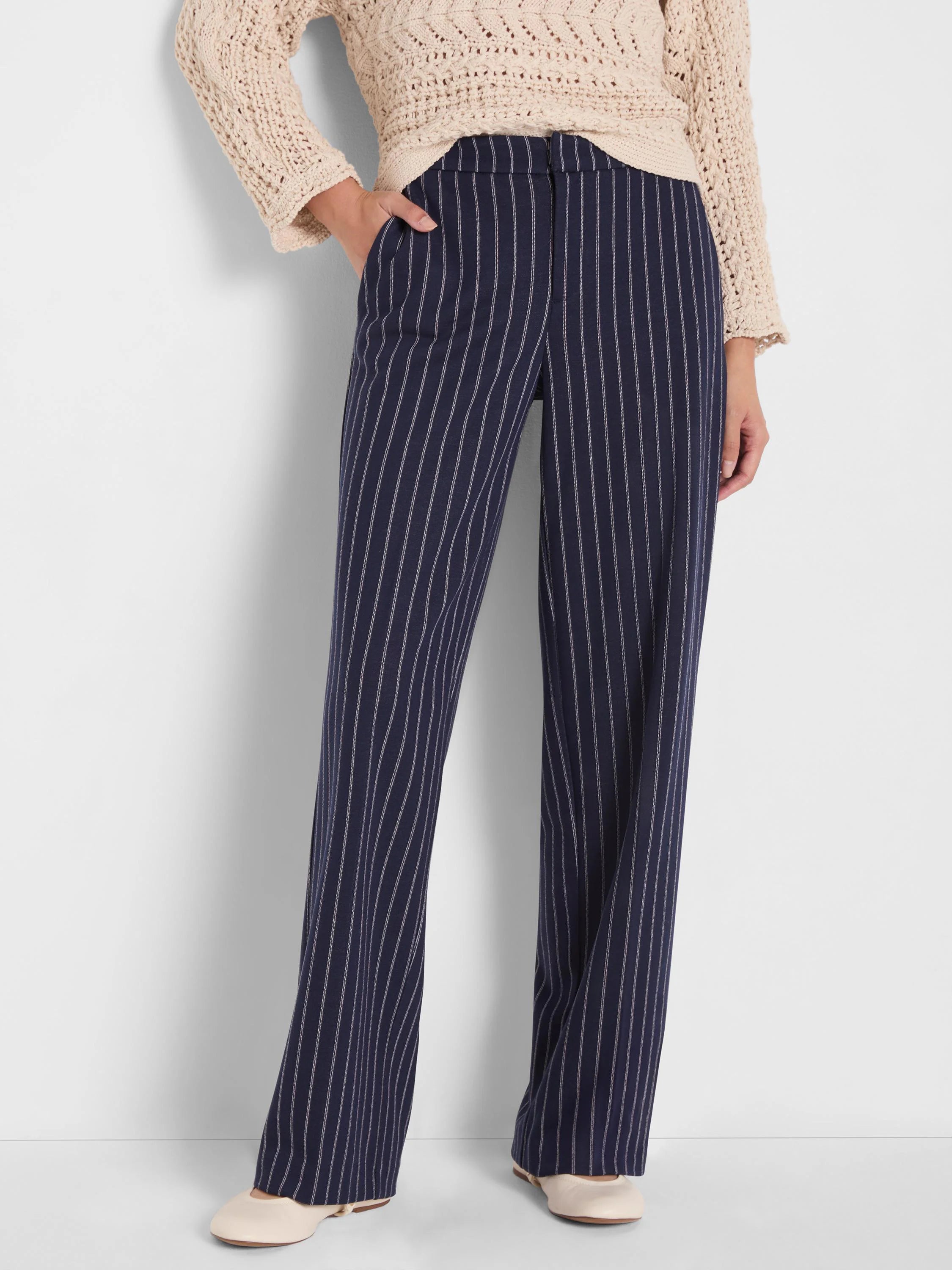 Navy wide-leg knit pants with fine white pinstripes, featuring slip pockets.