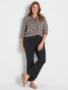 Leopard print button-up top with a ruffled collar and 3/4 sleeves. Cream, tan, and dark brown spots.