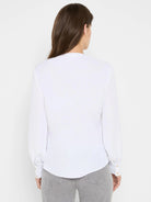 Back view of a white long-sleeved top with light buttoned cuffs and a curved hemline.
