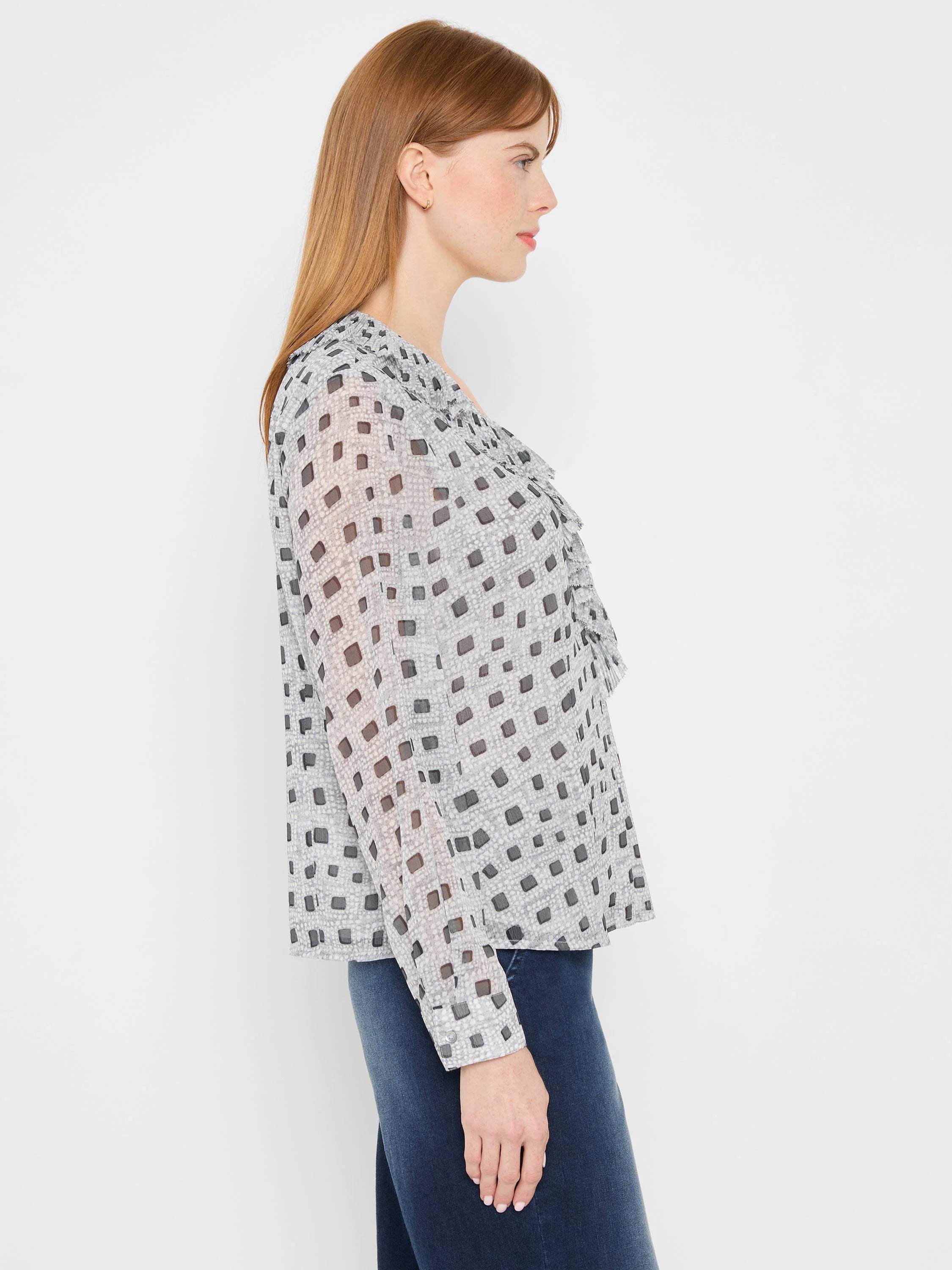 Light grey ruffle top with dark grey squares pattern and long sleeves, featuring ruffles along the neckline.
