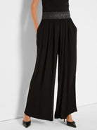 Black wide-leg palazzo pants, ruched faux leather waistband, and side pockets.