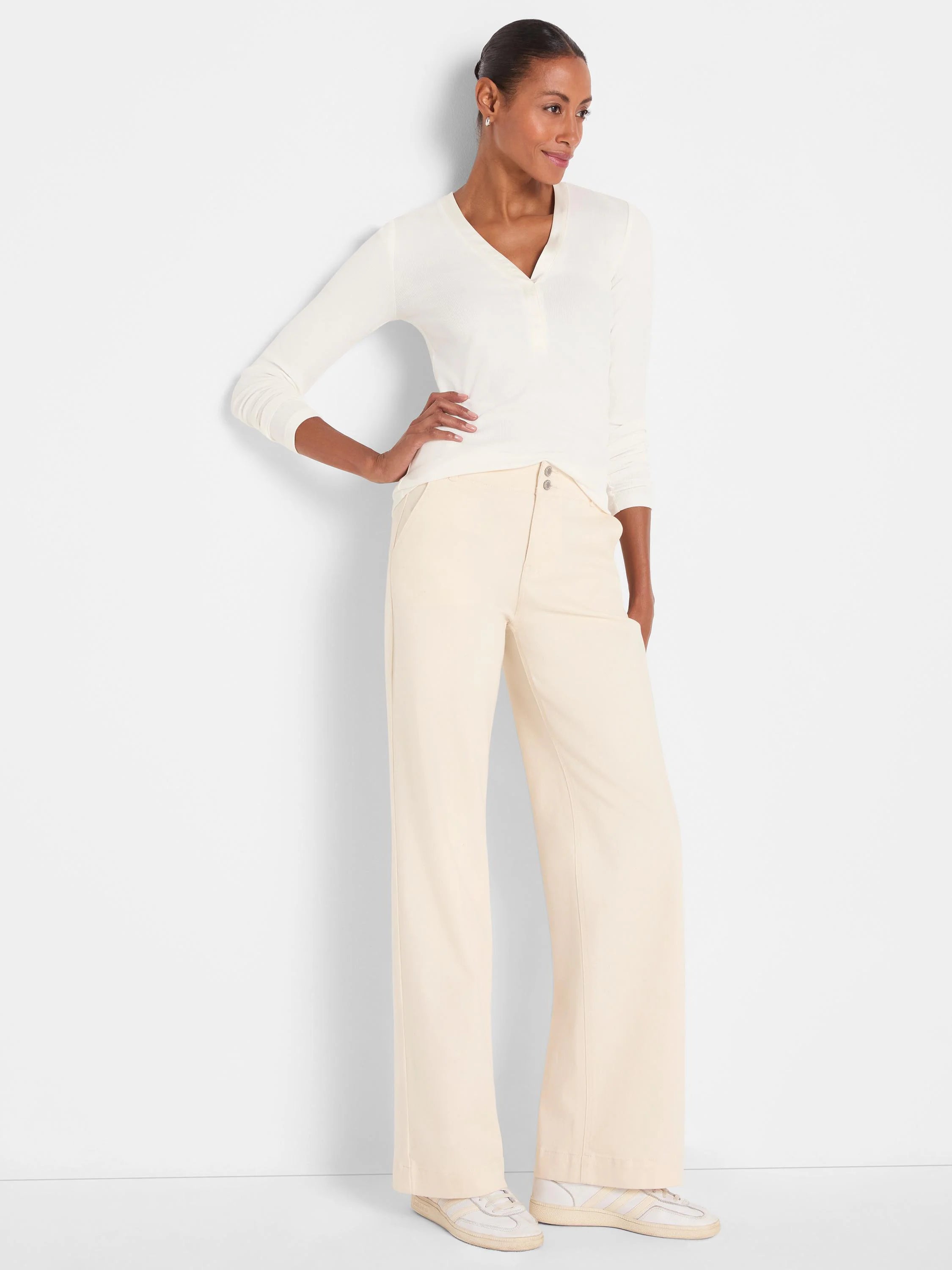 Cream wide-leg trouser jeans on a model, featuring a two-button waist and smooth fabric.