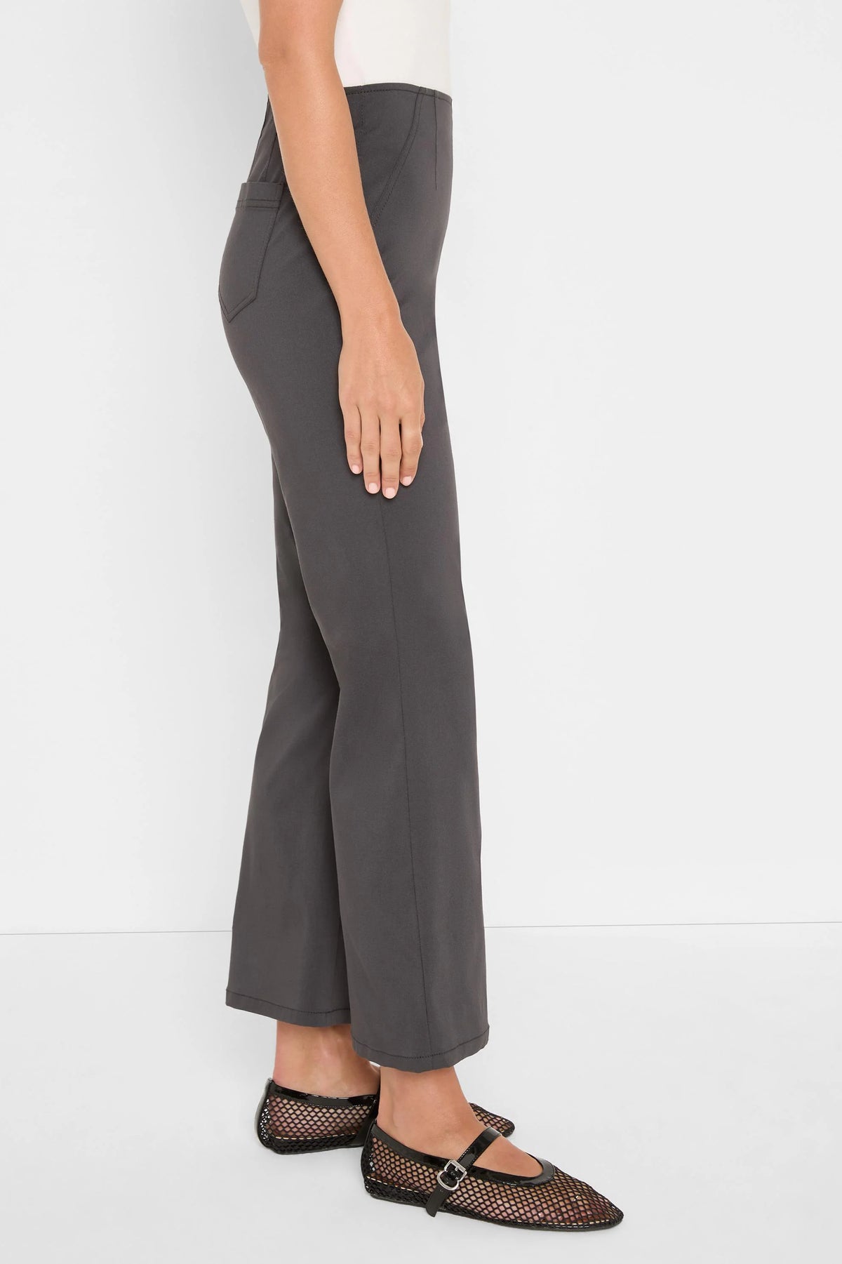 Dark grey high-waisted bootcut pants, smooth fabric with a subtle leg flare.