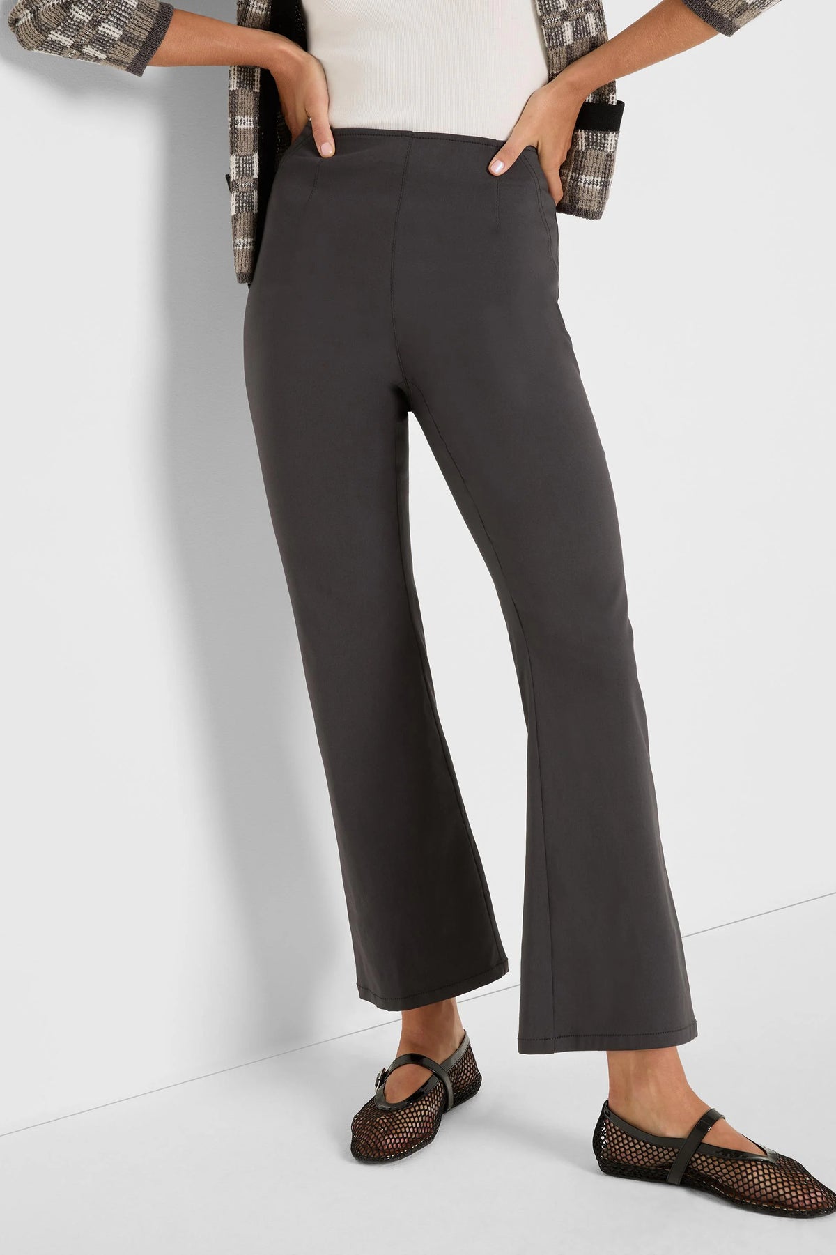 Dark grey bootcut pants on a model. Features a high waist, smooth fabric, and a slight flare at the hem.