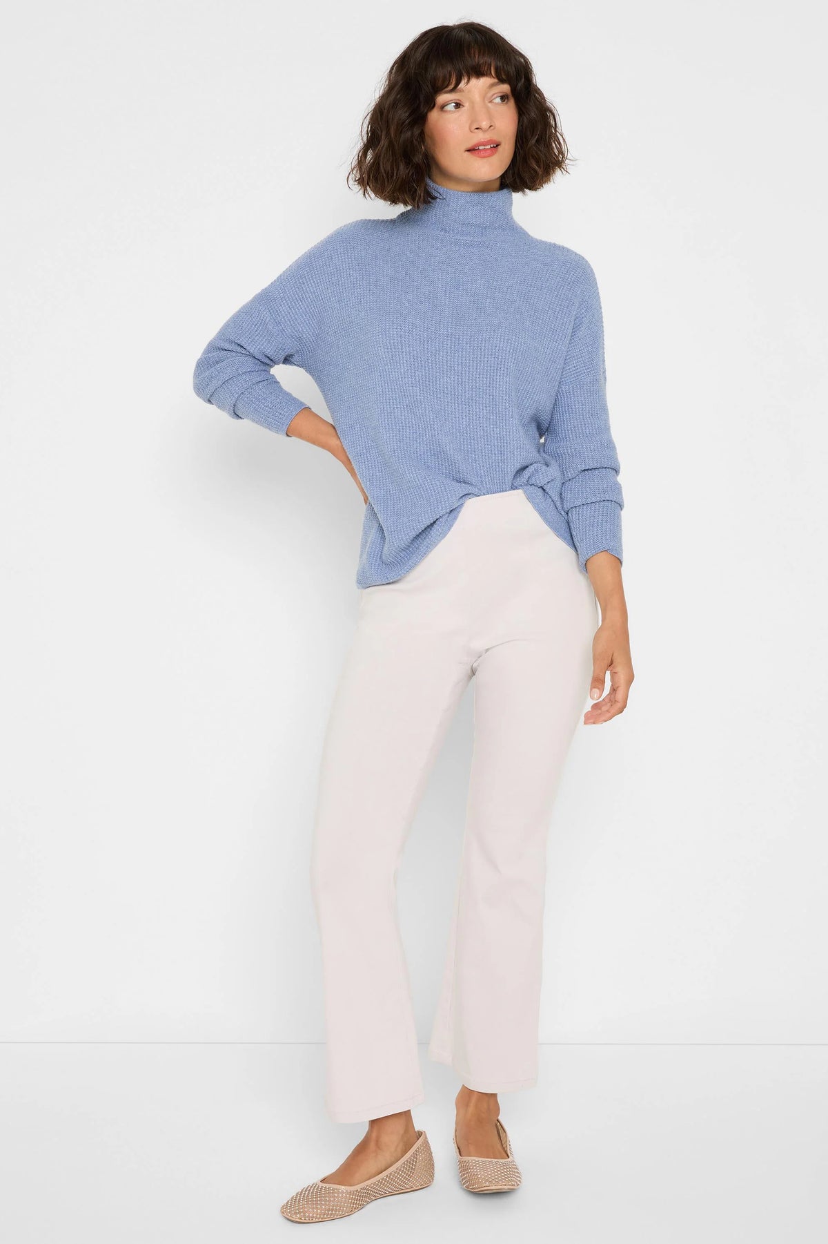 Light beige, cropped bootcut pants with a smooth finish.
