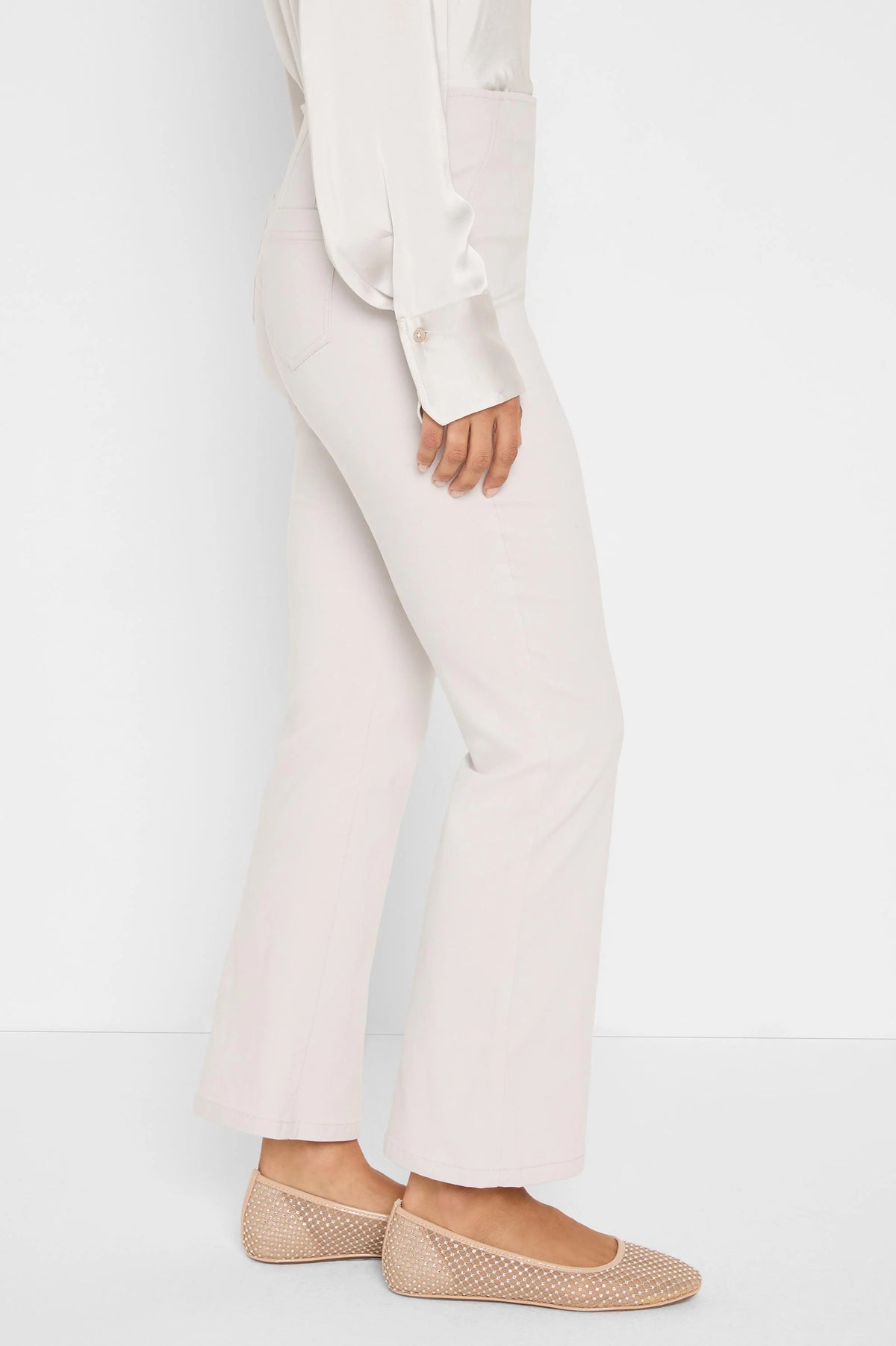 Light beige full-length bootcut pants, worn by a person.