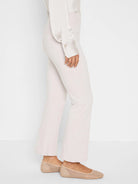 Light beige full-length bootcut pants, worn by a person.