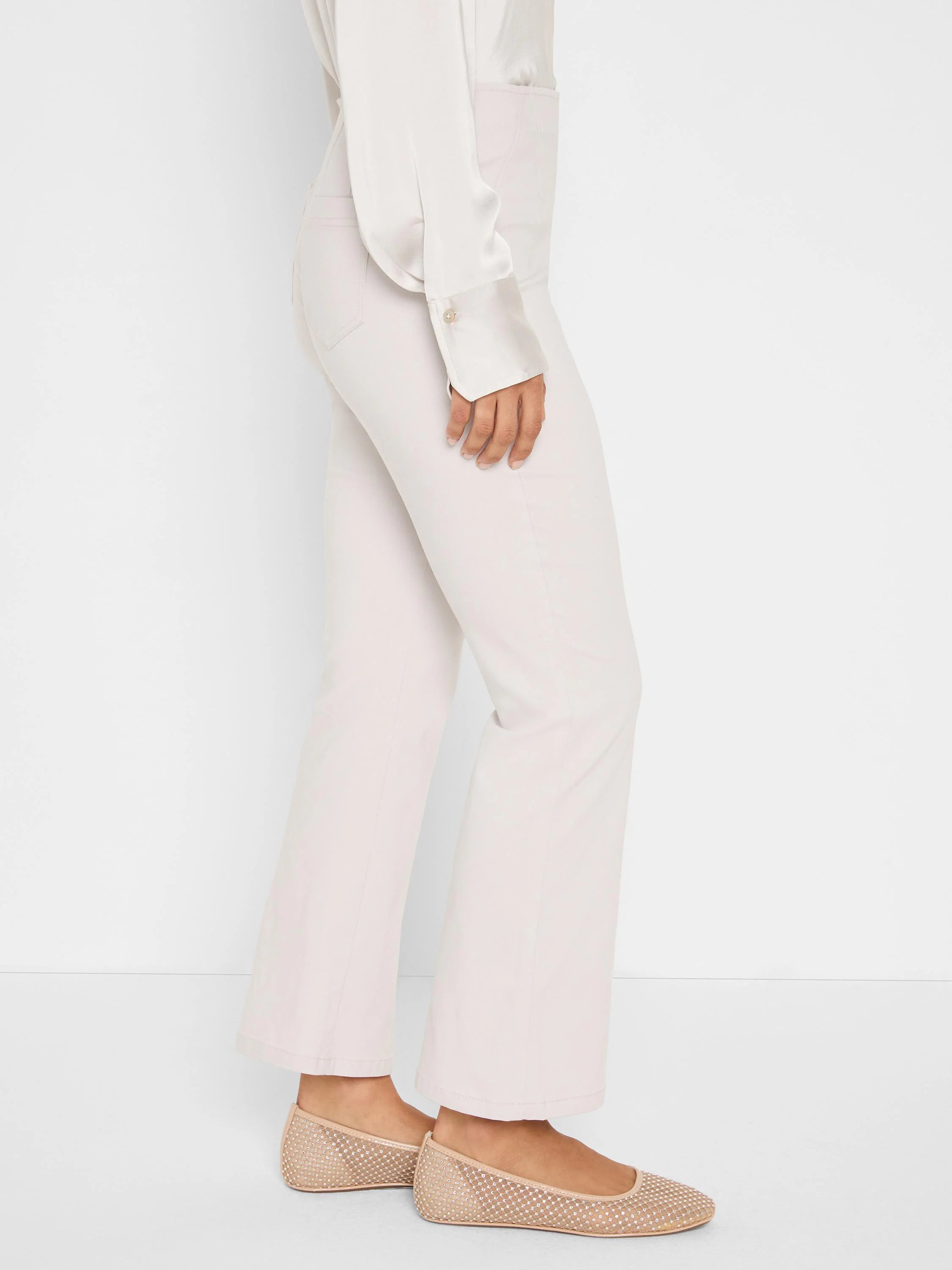 Light beige full-length bootcut pants, worn by a person.
