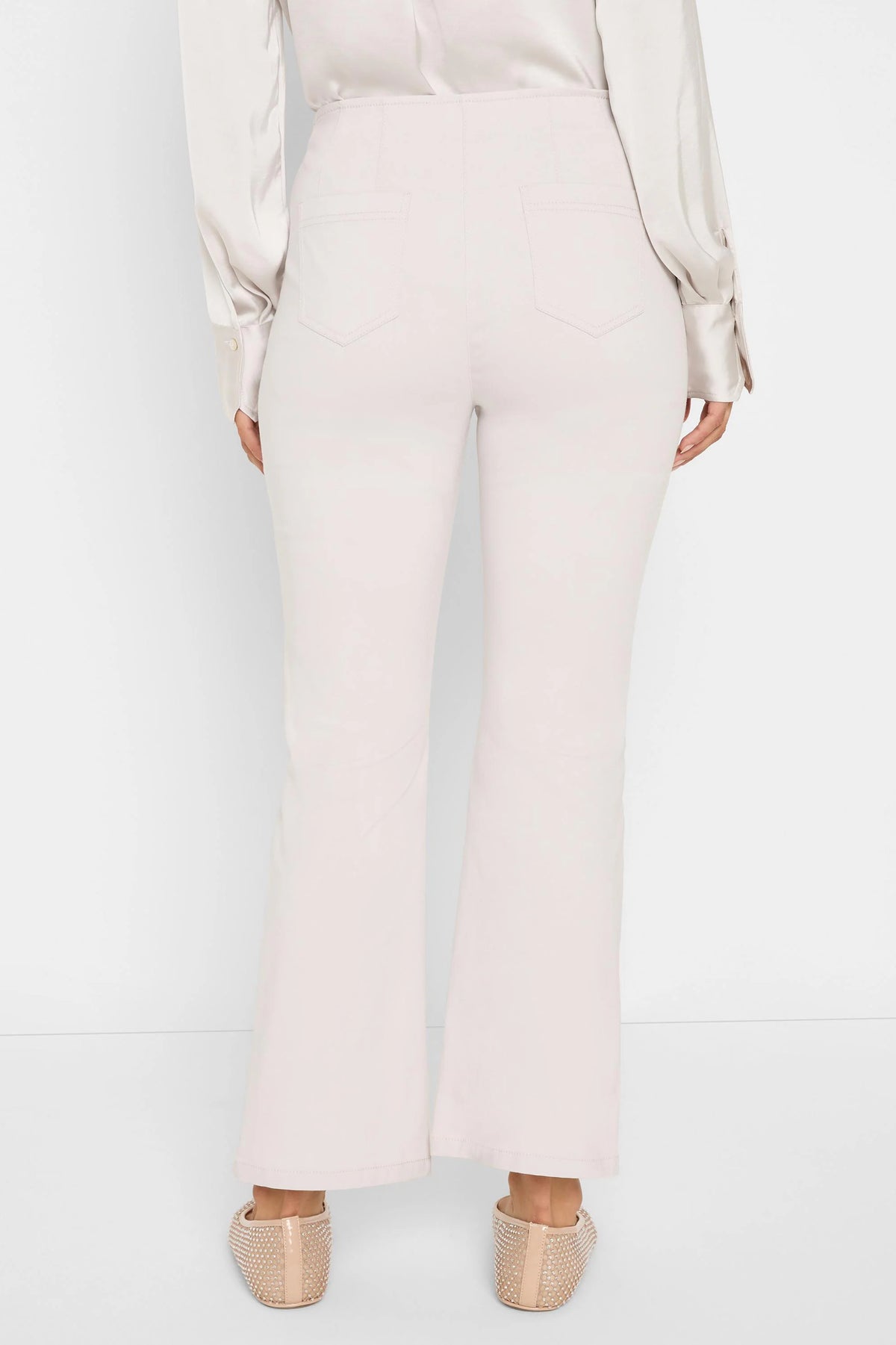 Pale beige bootcut pants, shown from the back. Features a high waist and two back patch pockets.