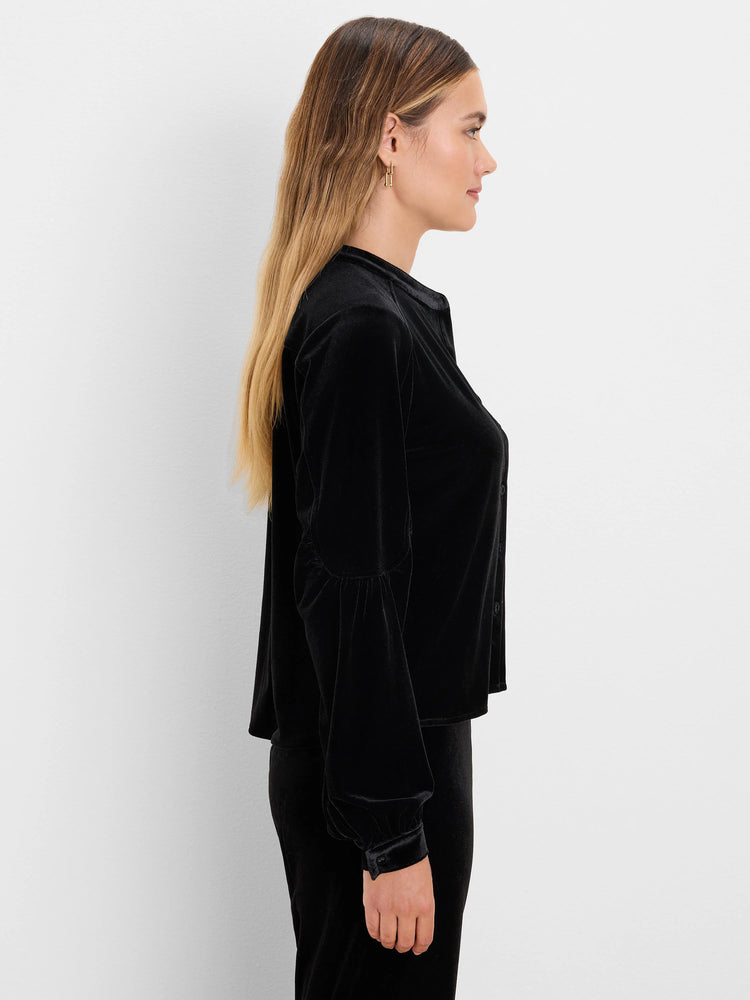 Black velvet top, model side profile. Features a band collar, puffed long sleeves with button cuffs.