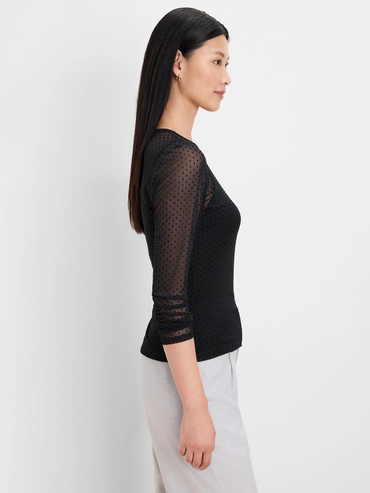 Black top with sheer mesh, raised velveteen dots. Fitted bodice and 3/4 ruched sleeves.