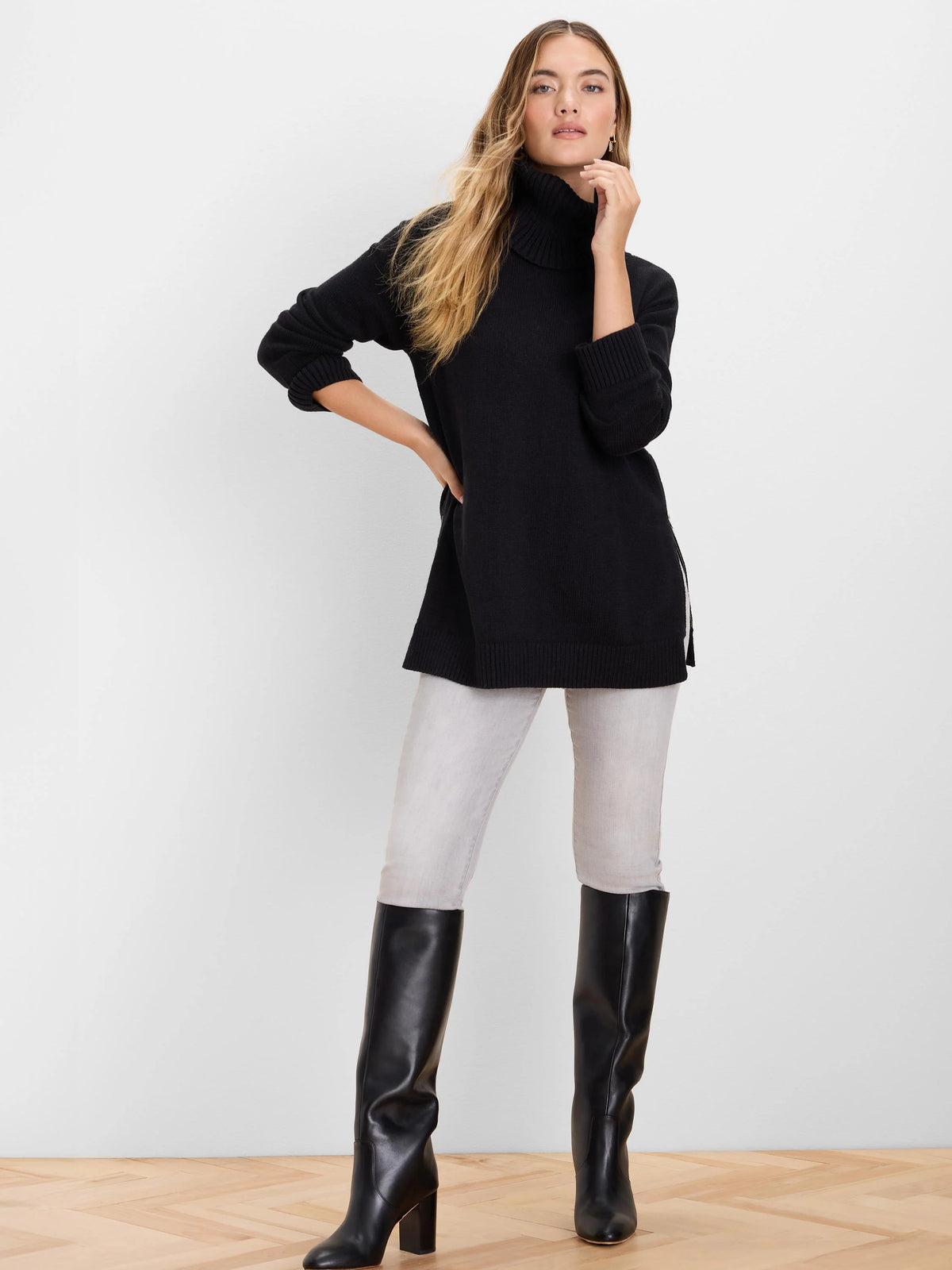 Black foldover turtleneck sweater with a relaxed fit and side slits.