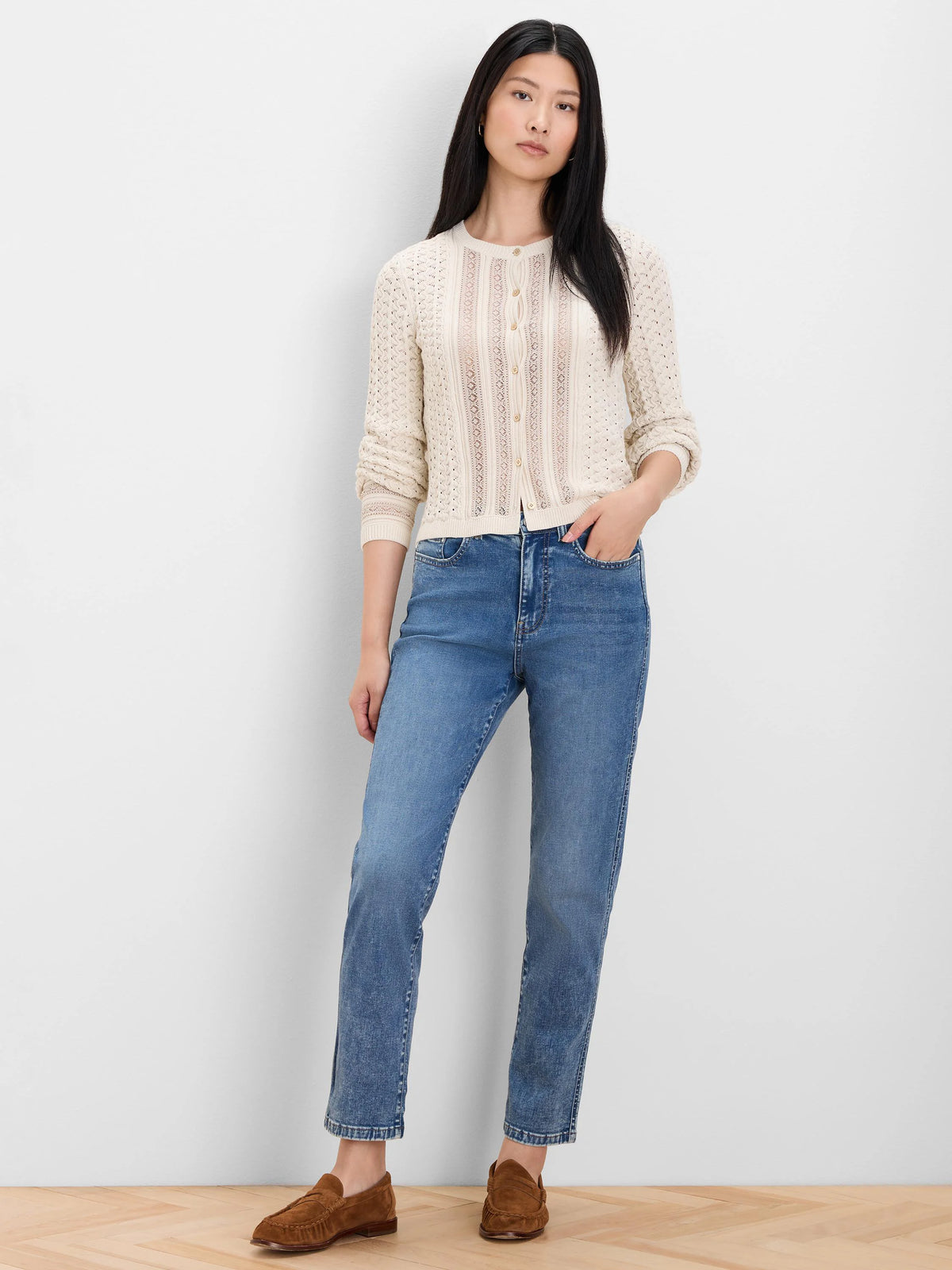 Cream filigree knit cardigan with an openwork pattern, light buttons down the front.