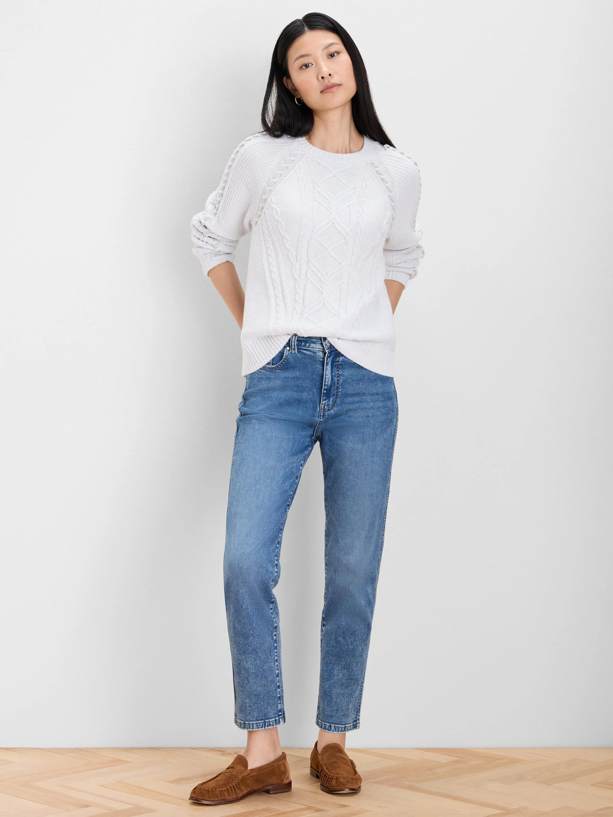 Off-white sweater with varied cable knit patterns across the body and sleeves.
