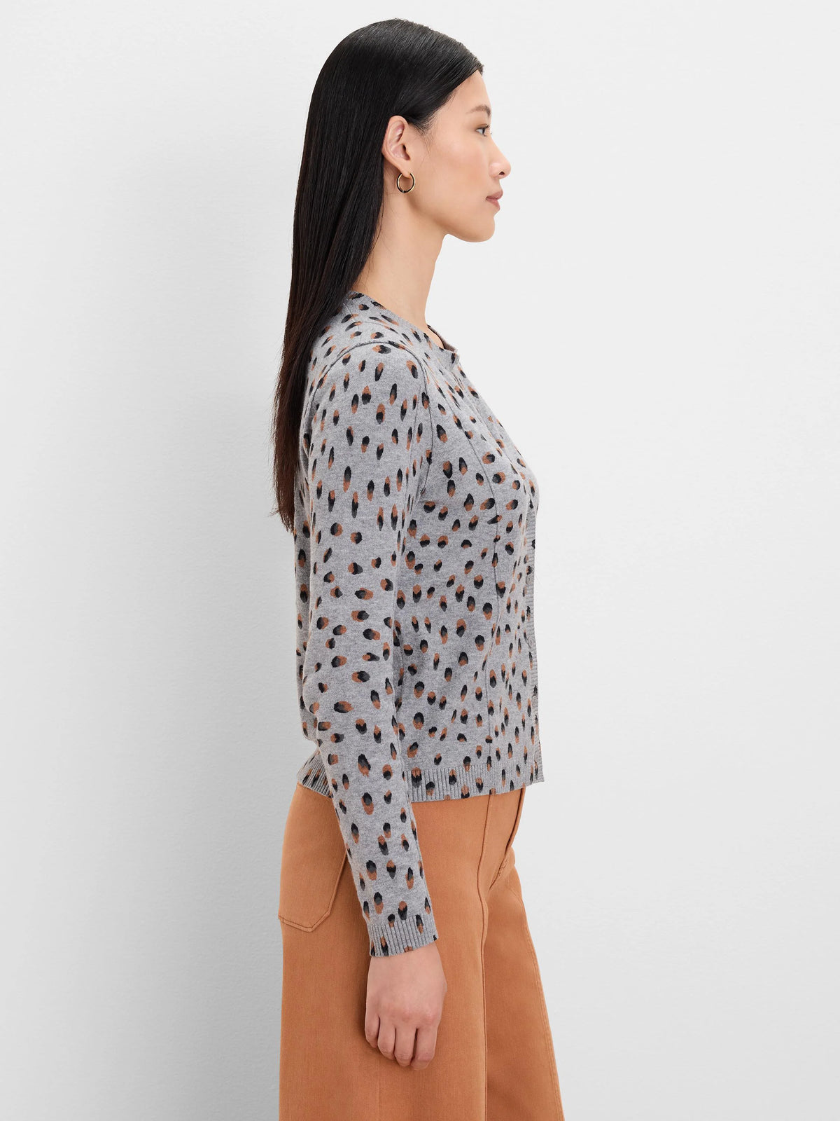 Light grey cardigan with scattered black and brown irregular dot pattern.