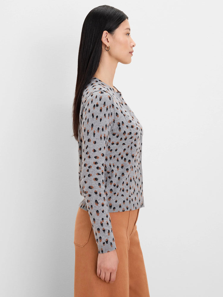 Light grey cardigan with scattered black and brown irregular dot pattern.