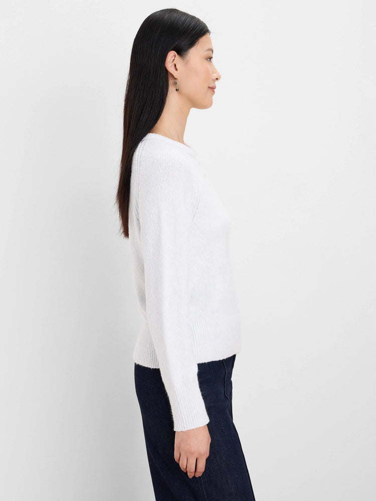 Off-white fuzzy, long-sleeved sweater with a crew neck, worn by a model.