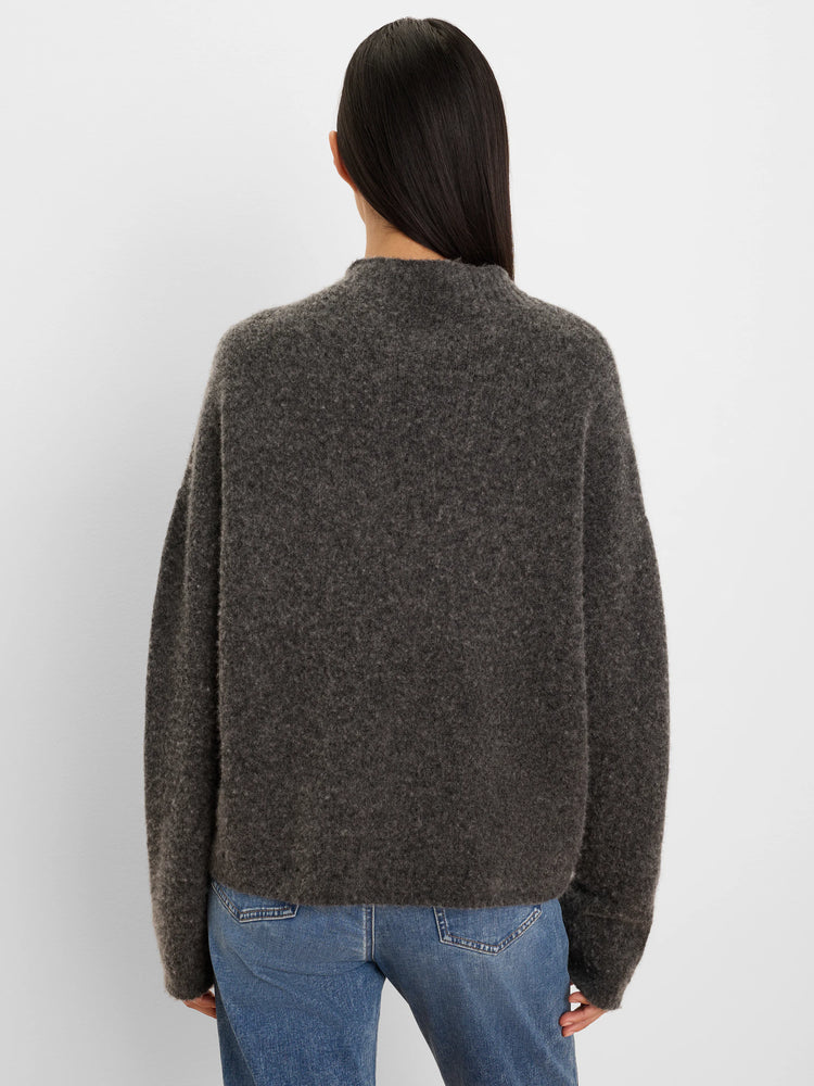 Loose-fitting, dark grey, fuzzy knit sweater with a high neck, seen from the back.