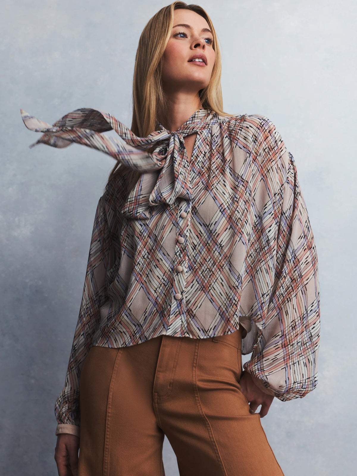 Light beige painted plaid shirt with peach, lavender, black lines, a tie neck, and full sleeves.